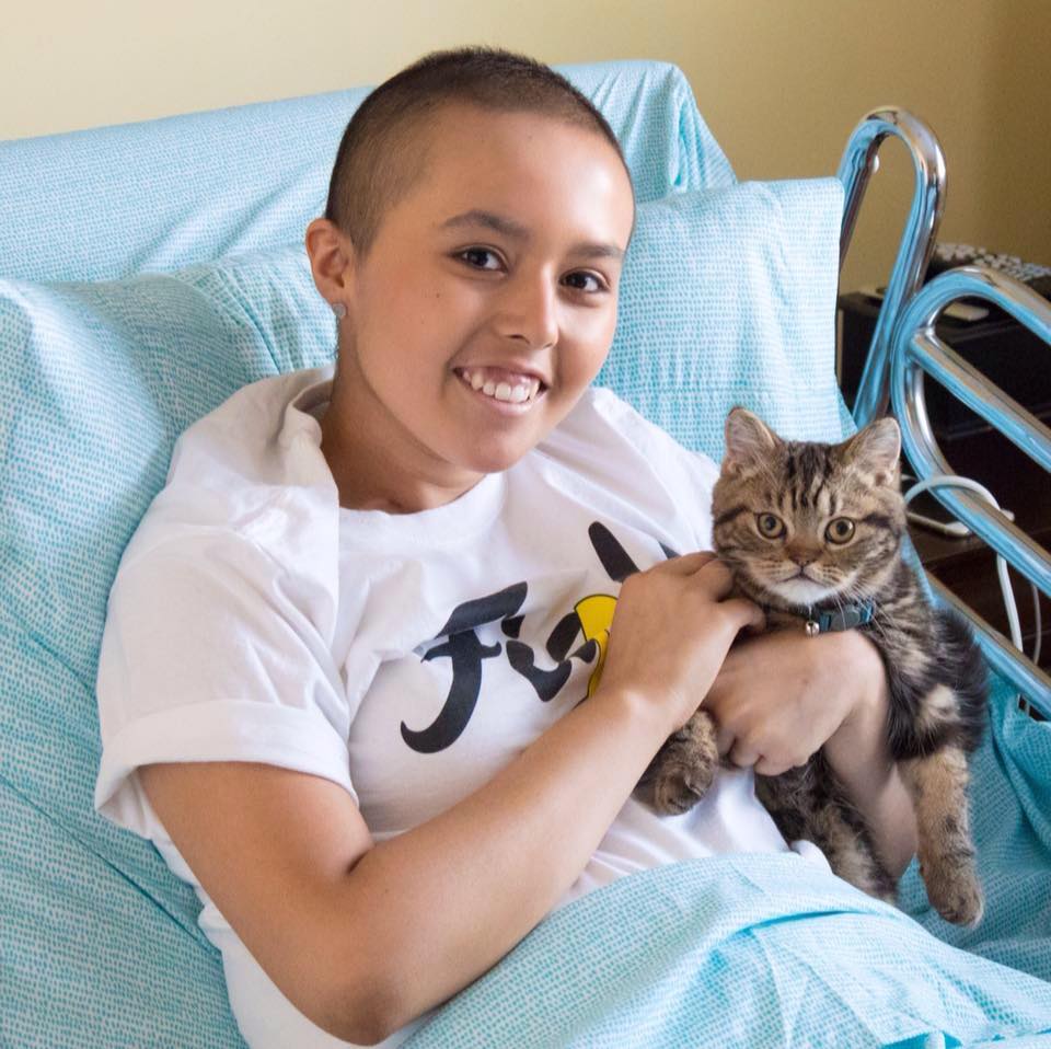 Anissa in a hospital bed with a cat.