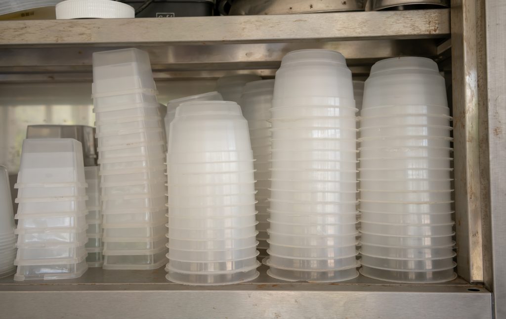 Stacks of plastic bowl and food container in kitchen for takeaway or delivery.
